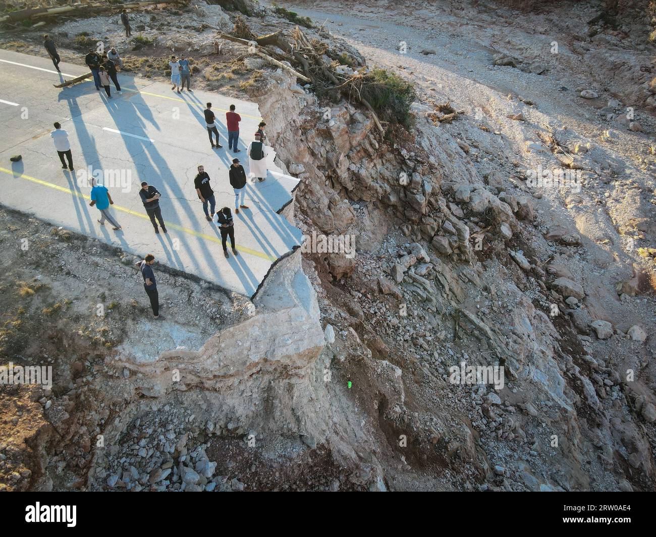 (230916) -- DERNA, 16 septembre 2023 (Xinhua) -- cette photo aérienne prise le 15 septembre 2023 montre des gens debout sur l'autoroute brisée entre Derna City et Sousse City, dans l'est de la Libye. L'autoroute était à l'origine reliée à un pont qui a été détruit lors des récentes inondations. L’Organisation internationale pour les migrations (OIM) a déclaré vendredi que plus de 38 640 000 personnes ont été déplacées dans les zones les plus touchées du nord-est de la Libye après de fortes inondations déclenchées par la tempête méditerranéenne Daniel qui ont balayé la région. L’OIM a déclaré dans un communiqué que 2 217 bâtiments avaient été détruits à Derna, le por Banque D'Images