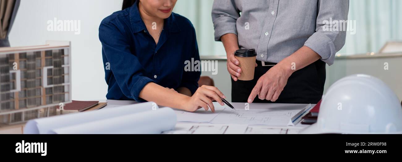 Deux architectes pointant sur le plan à l'analyse et la planification sur le projet de construction de bâtiment. Banque D'Images