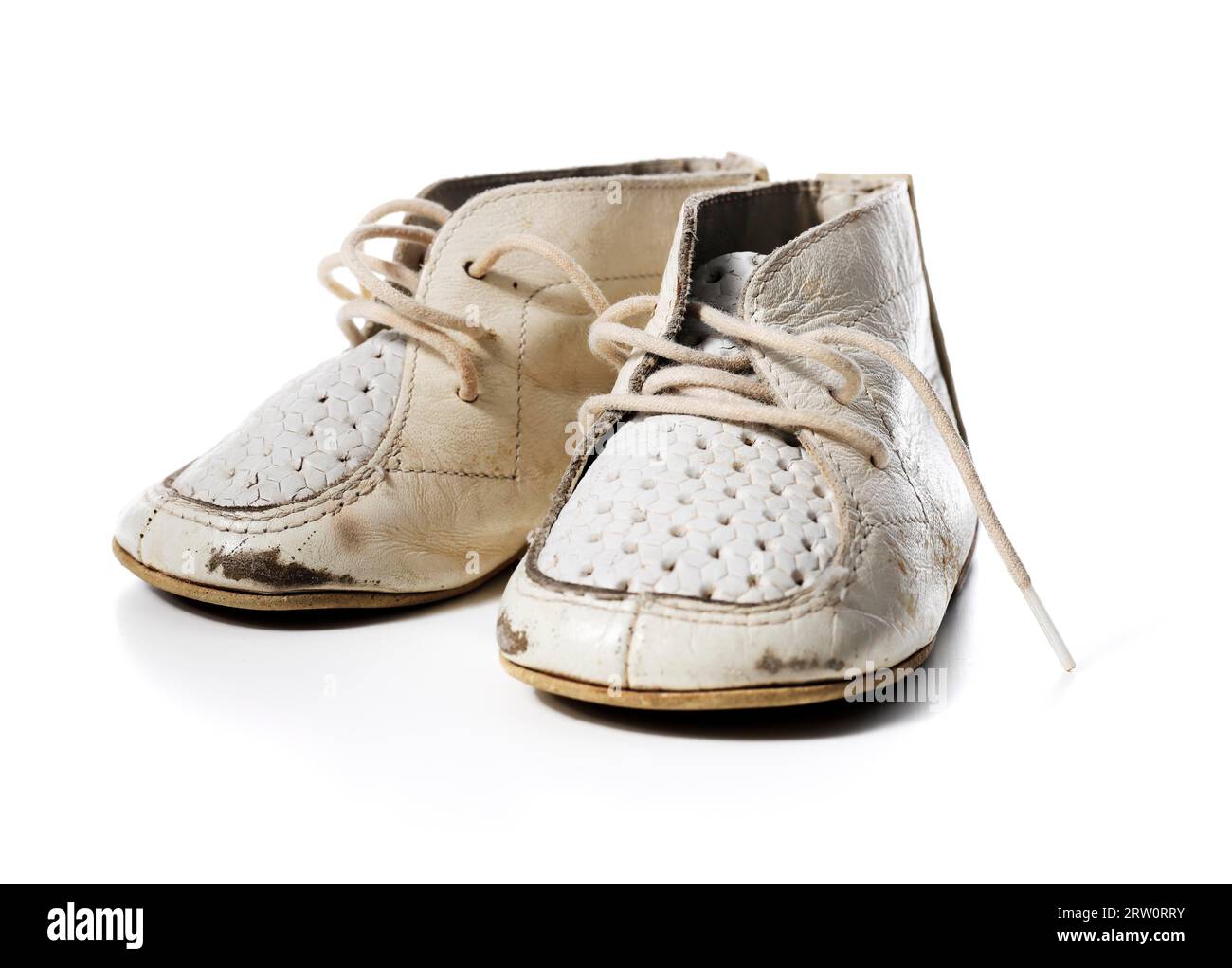 Vieux vieux vieux cuir vintage chaussures de bébé blanc isolé sur blanc avec des ombres naturelles Banque D'Images