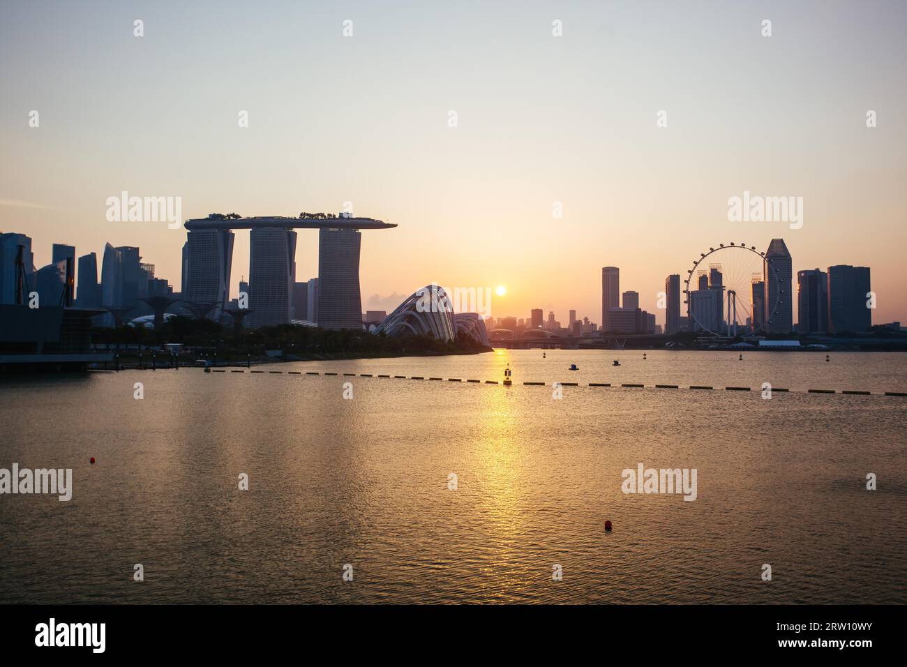 Marina Bay, Singapour, 23 juin 2015 : Marina Bay Sands et jardins près de la baie avec horizon de la ville au crépuscule Banque D'Images