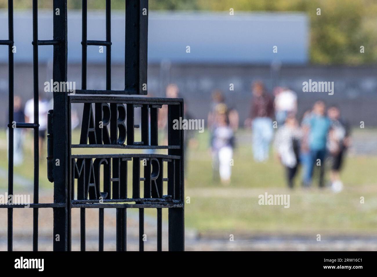 Oranienburg, Allemagne. 15 septembre 2023. Vue de la porte d'entrée avec l'inscription 'Arbeit macht frei' ('le travail vous libère') ; en arrière-plan, les visiteurs marchent sur le terrain de l'ancien camp de concentration de Sachsenhausen. Crédit : Hannes P. Albert/dpa/Alamy Live News Banque D'Images