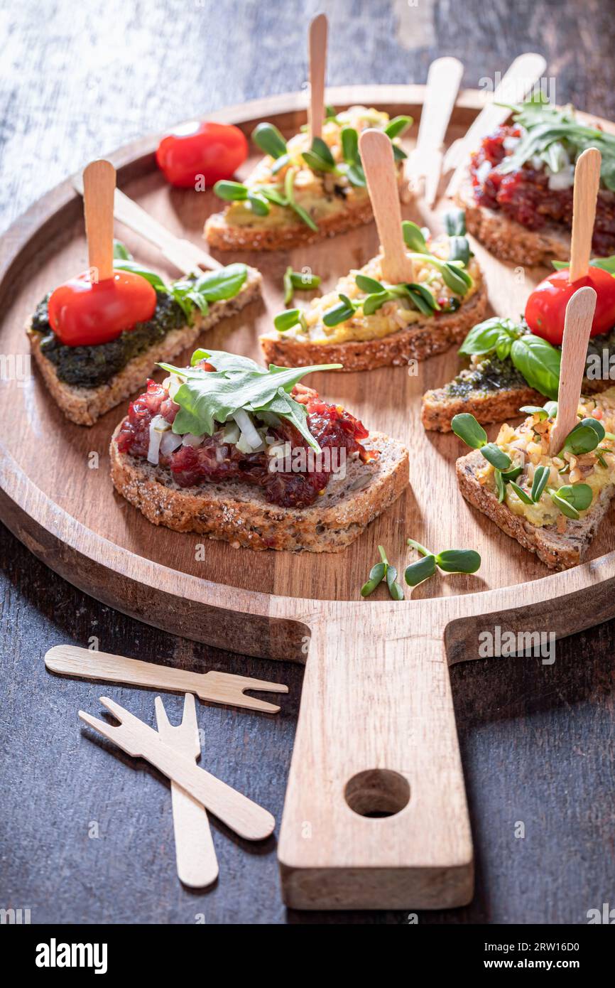 Bruschetta maison avec tomate et pesto pour le petit déjeuner sur une planche de service. Banque D'Images