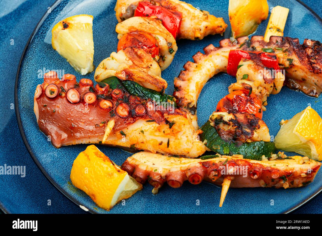 Savoureux fruits de mer poulpe tentacules brochettes sur assiette bleue. Banque D'Images