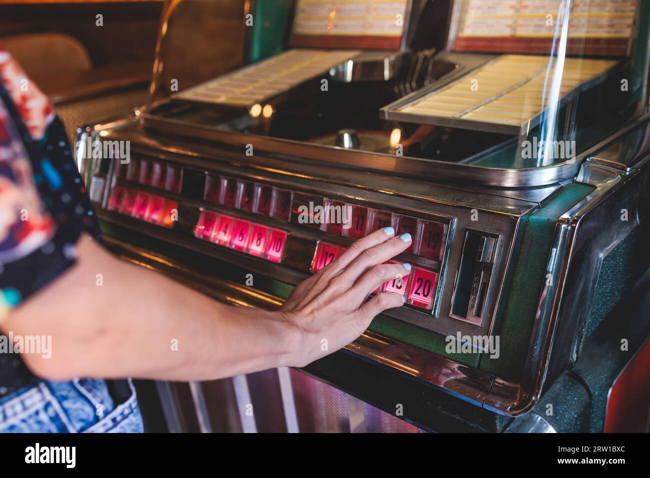 Juke-box de musique américaine vintage avec boutons illuminés, processus de choix de la composition de la chanson, juke-box rétro à l'ancienne avec disques vinyles musicaux b Banque D'Images