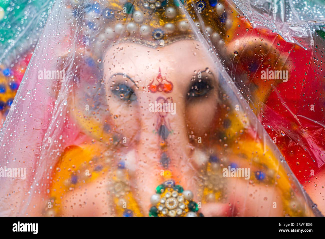 Ganpati recouvert de plastique avec goutte de pluie dessus Banque D'Images