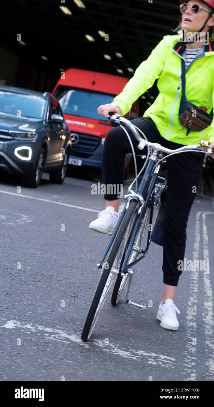 Vue verticale femme cycliste cycliste vélo attendant sur la route dans le trafic tunnel de Beech Street pour les lumières pour changer Londres E2 UK KATHY DEWITT Banque D'Images