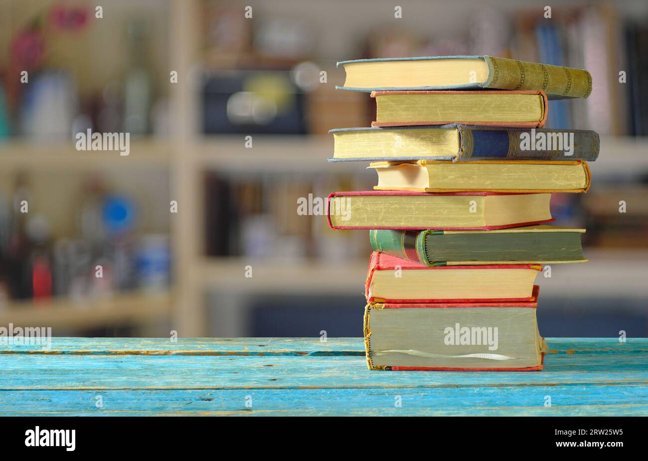 Pile de livres avec fond de bibliothèque flou, lecture, apprentissage, éducation ou concept de bureau à domicile Banque D'Images