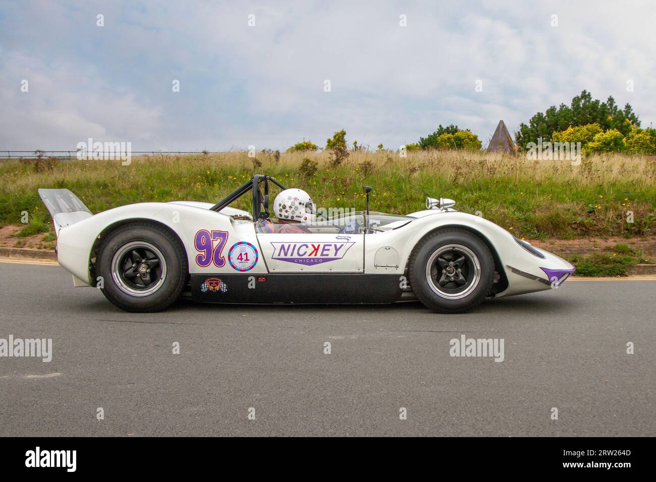 Années 1965 60 années soixante blanc violet McLaren 5987 cc M1A à l'Ocean Speed Revival Southport Sprint sur Marine Drive, classique et vitesse sur une route publique fermée Coastal Road parcours de sprint historique, Merseyside, Royaume-Uni Banque D'Images