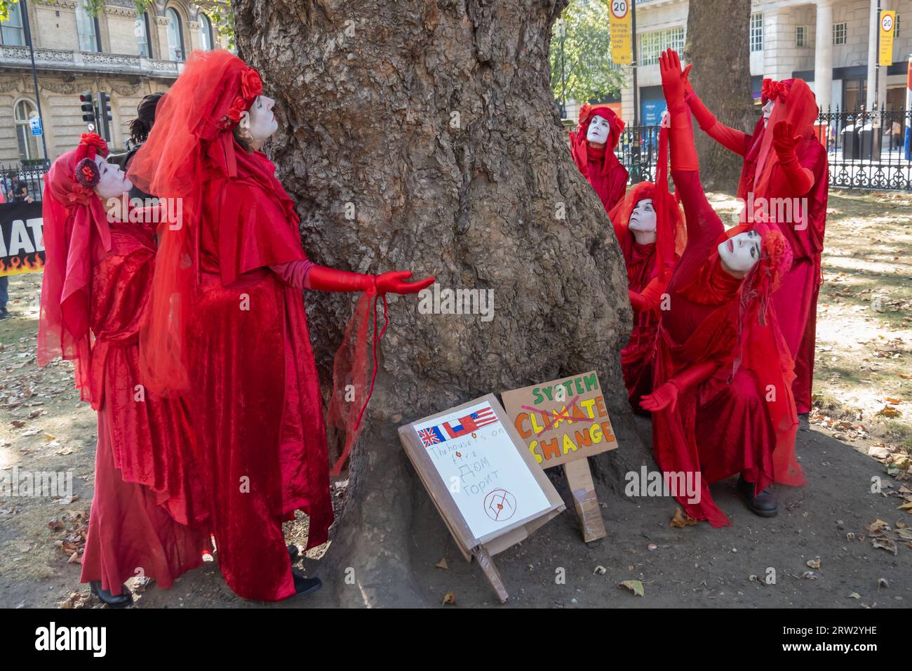 Londres, Royaume-Uni. 16 septembre 2023. Les rebelles rouges adorent un arbre. Les gens défilent à Londres dans le cadre des actions menées par des millions de personnes dans le monde pour exiger que les dirigeants mondiaux réunis à New York pour le Sommet sur l’ambition climatique du Secrétaire général des Nations Unies prennent les mesures urgentes nécessaires pour une fin juste et équitable de l'utilisation de tous les combustibles fossiles. Peter Marshall/Alamy Live News Banque D'Images