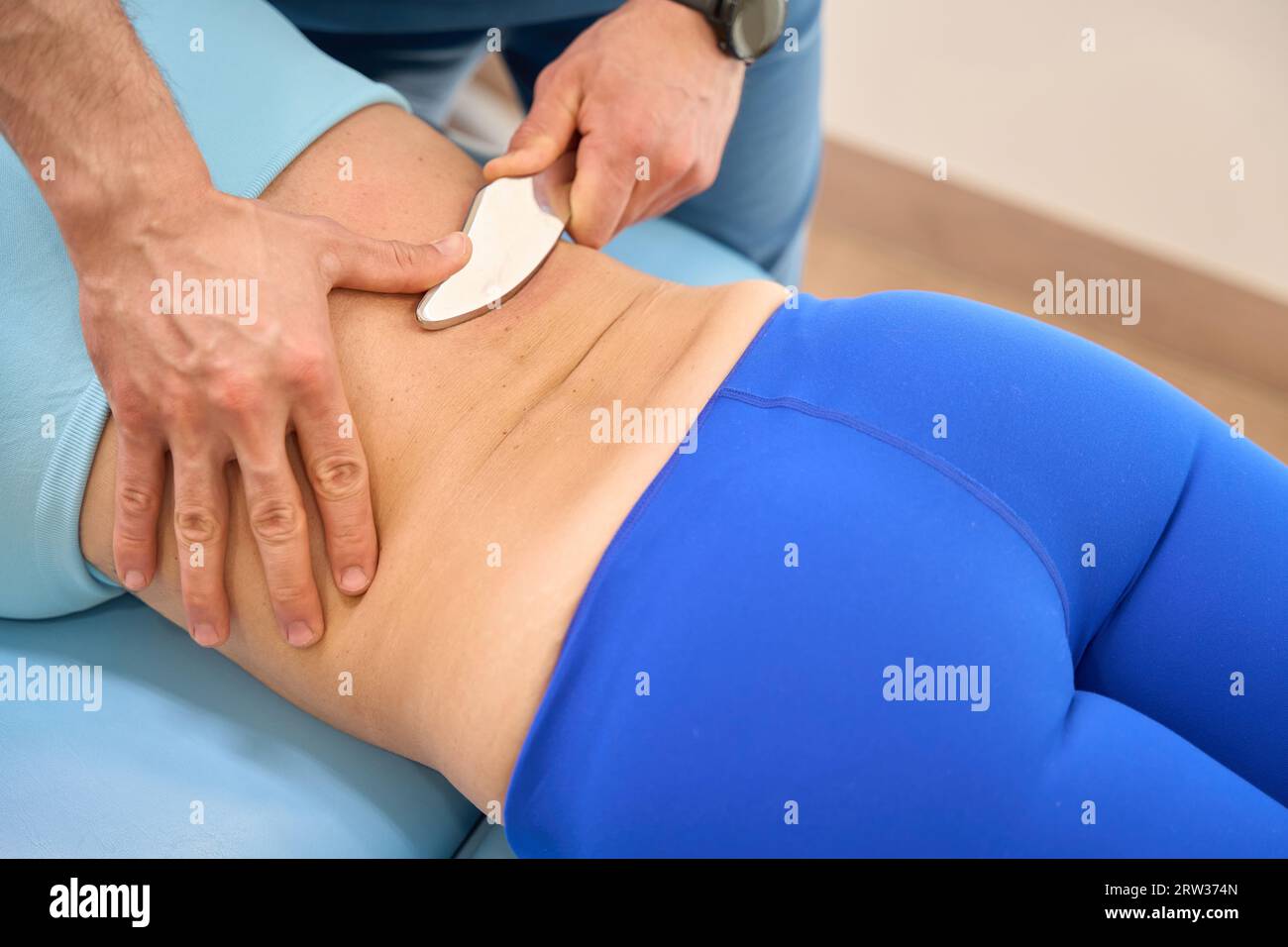 Thérapeute manuel professionnel pratiquant le massage chinois Gouache à la cliente femme Banque D'Images