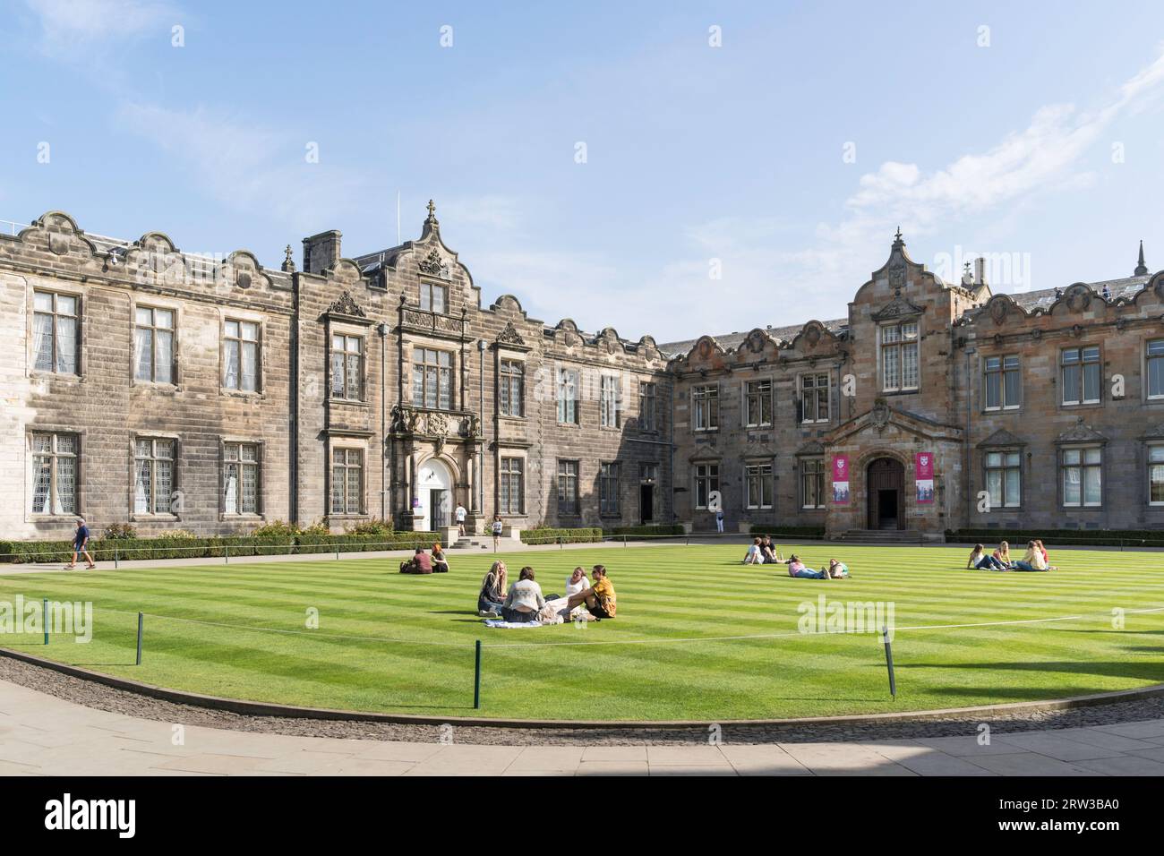 Étudiants assis sur l'herbe dans St Salvator's Quadrangle, Uniiversity of St Andrews, Fife, Écosse, Royaume-Uni Banque D'Images