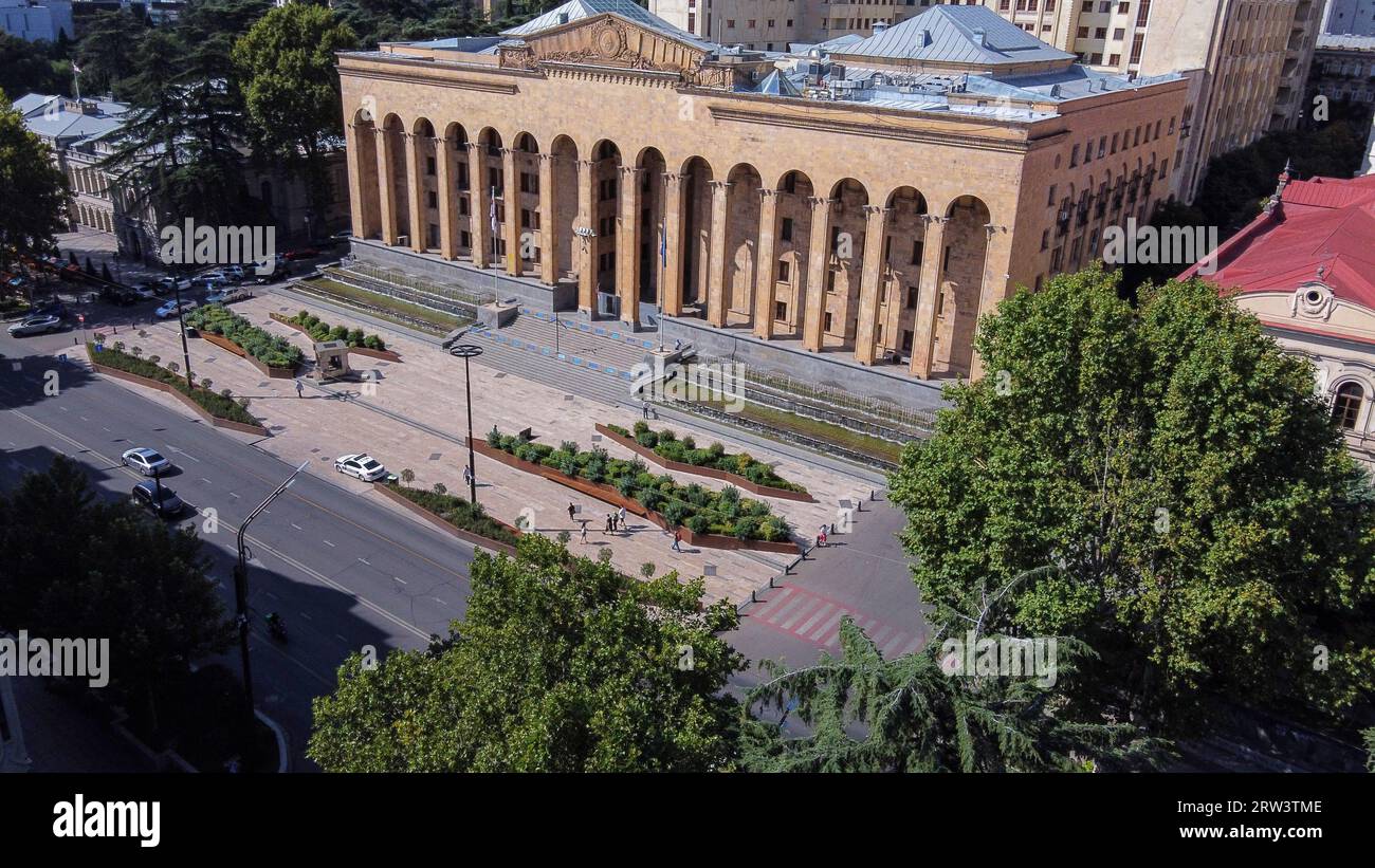 08-19-2023 Tbilis Georgia. Bâtiment du Parlement de la Géorgie avec des fontaines près des murs les gens dans la distance. Voiture de police, grandiose plantes clôturées entourées de c Banque D'Images