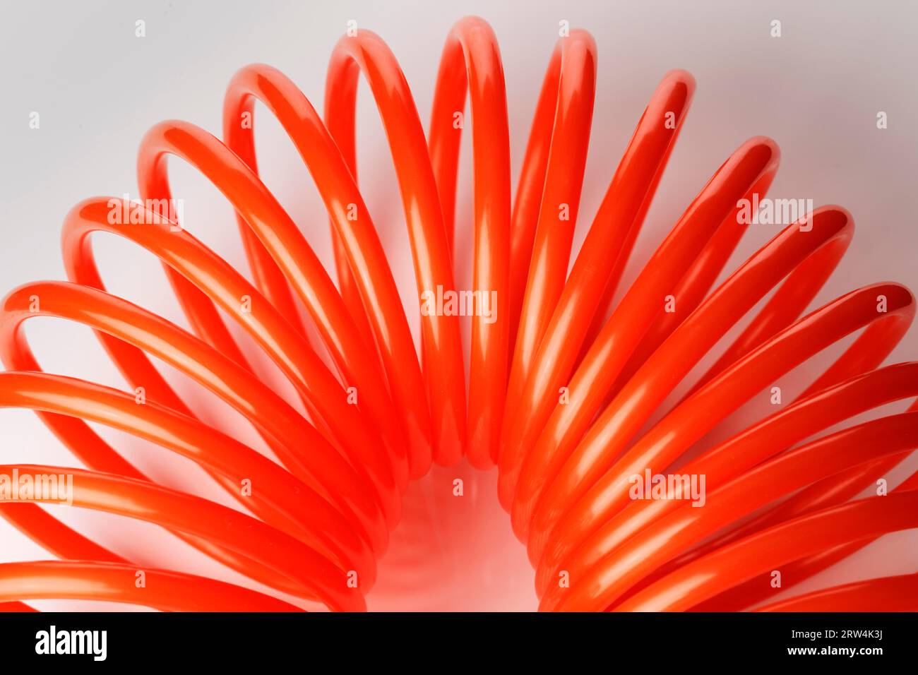 Tuyau d'air en plastique spiralé rouge orange utilisé pour les outils pneumatiques Banque D'Images