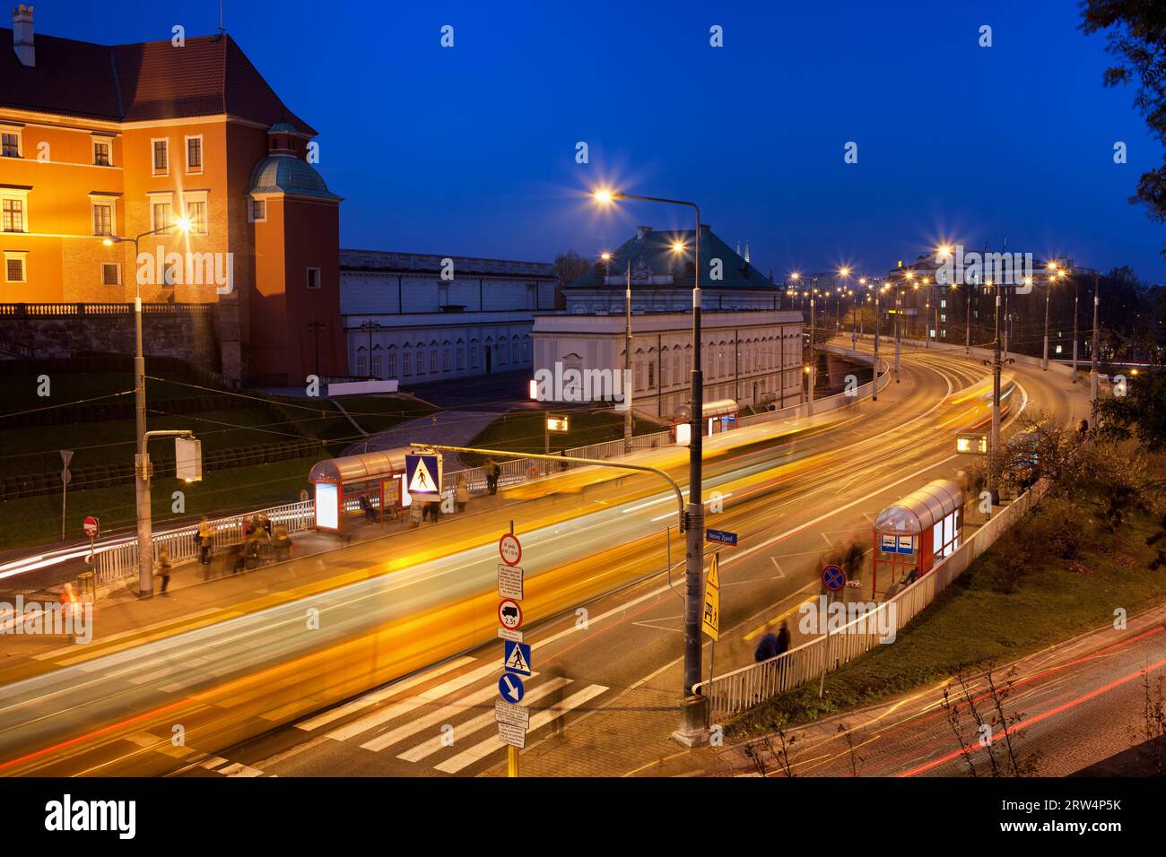 Circulation nocturne sur l'avenue Solidarnosci (polonais : Aleja Solidarnosci), les gens qui attendent aux arrêts de bus et de tram dans la vieille ville de Varsovie, Pologne Banque D'Images