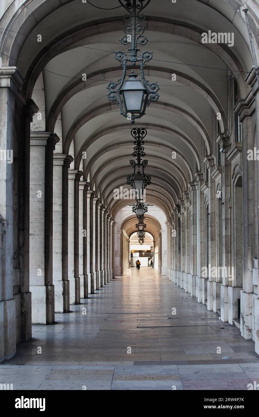 Arcade avec plafond voûté et lampes ornées en fer forgé dans le bâtiment de Praca do Comercio à Lisbonne, Portugal Banque D'Images