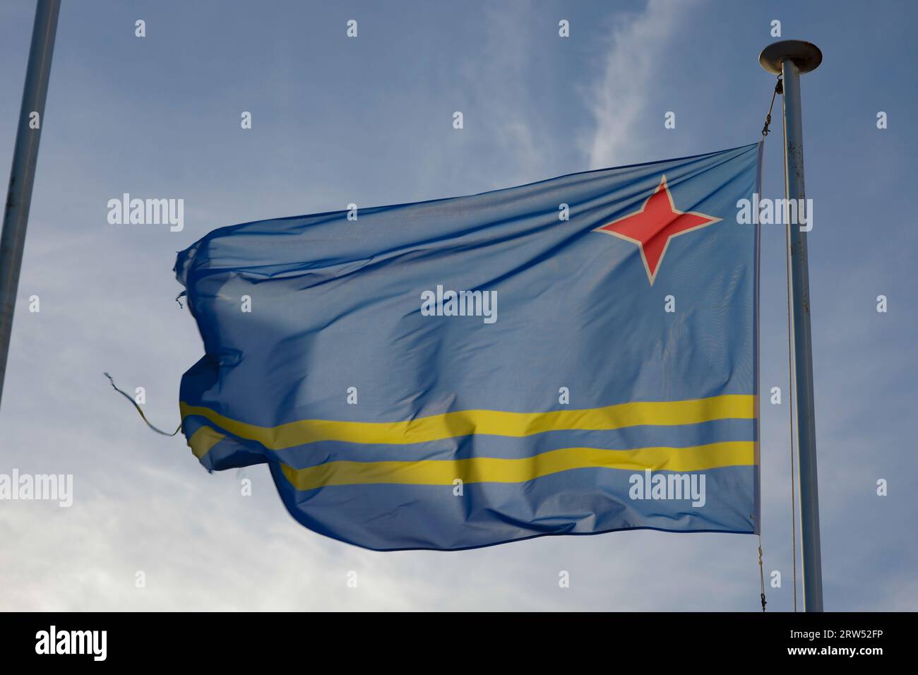 Drapeau Aruba et ciel bleu avec des nuages. Banque D'Images