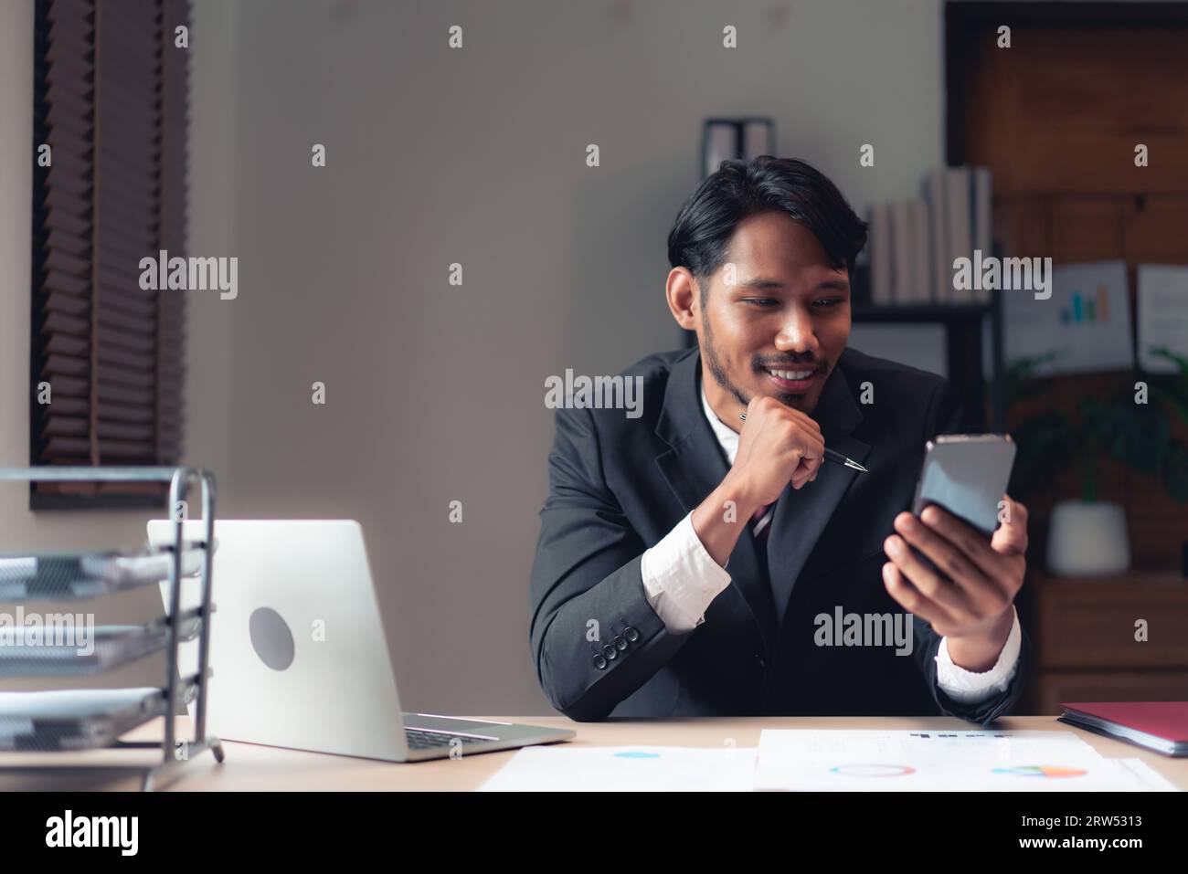 Homme d'affaires utiliser smartphone à la lecture du rapport pour penser à la finance et la comptabilité du projet. Banque D'Images