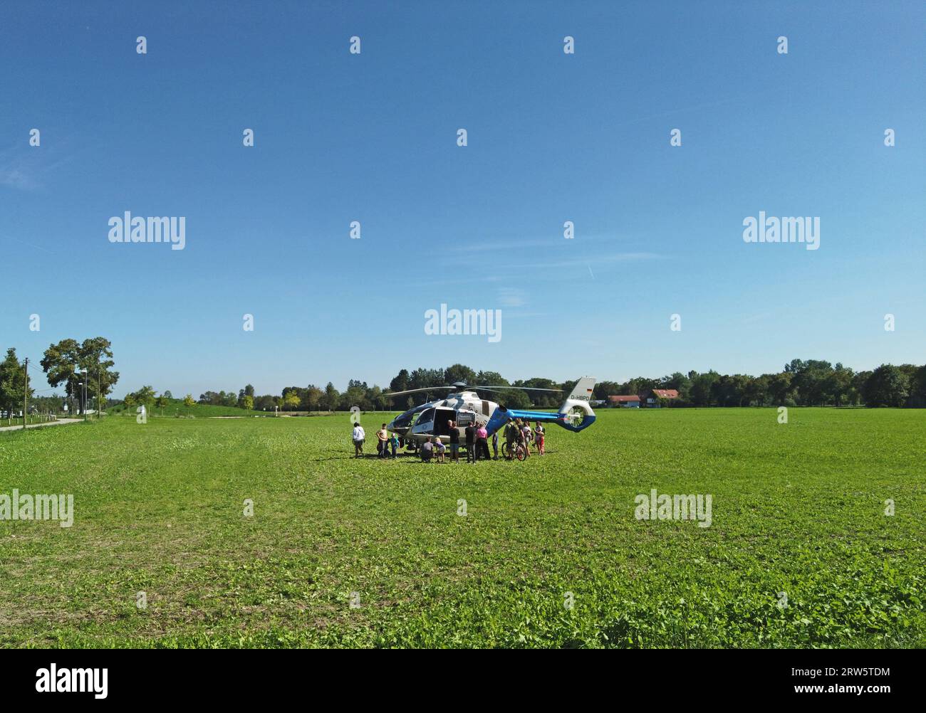 Garching BEI Muenchen, Allemagne - des personnes regardant curieusement un hélicoptère de la police bavaroise ont atterri dans un champ Banque D'Images