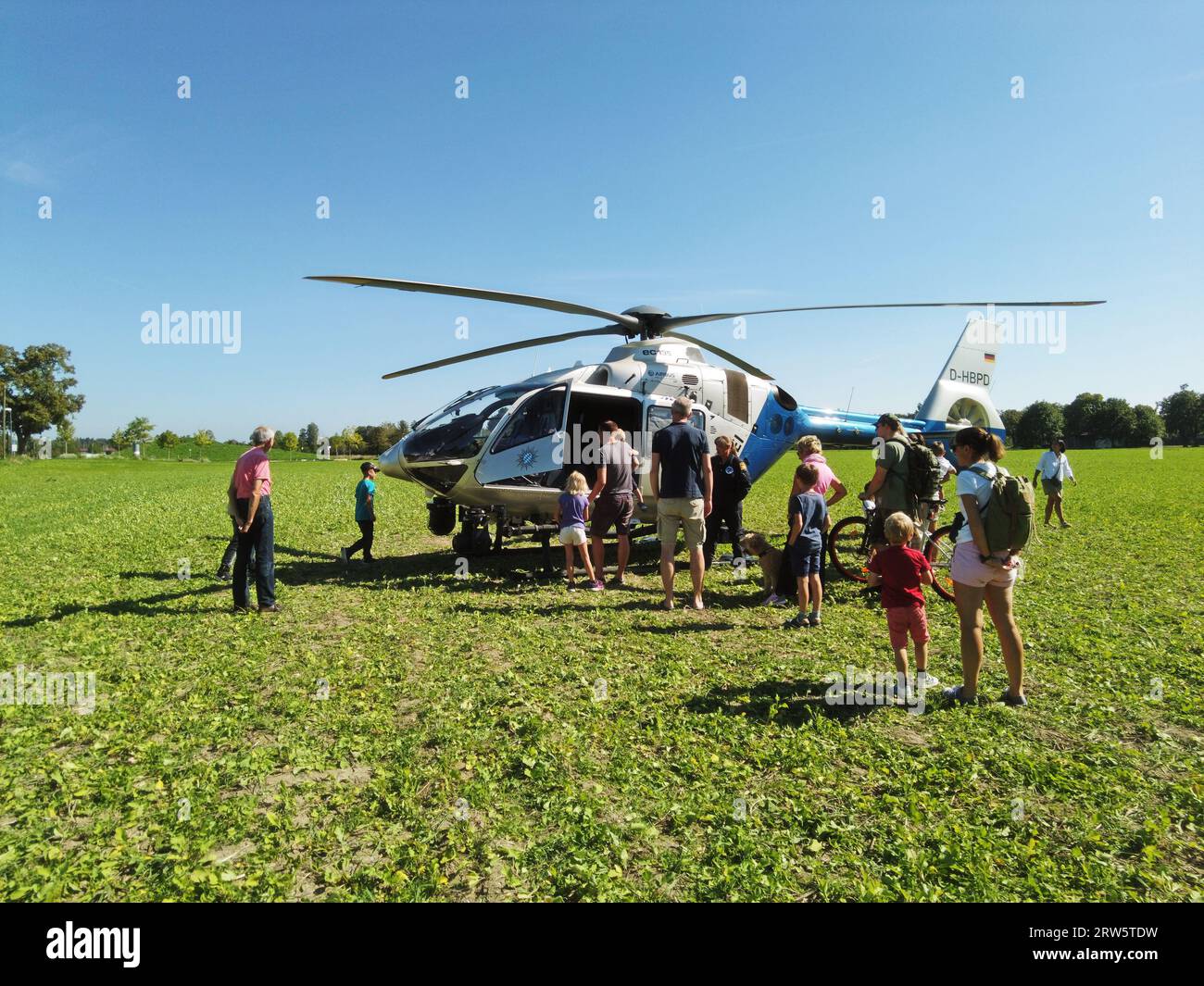 Garching BEI Muenchen, Allemagne - hélicoptère de la police bavaroise a atterri dans un champ, entouré de curieux passants amicaux accueillis Banque D'Images