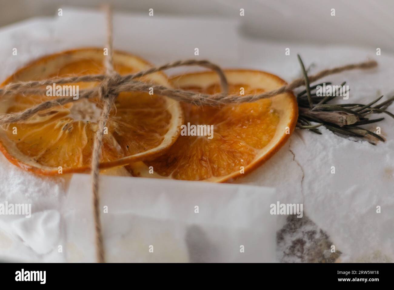 Stollen de Noël décoré avec des fruits orange secs et branche d'épicéa. Cuisson des fêtes du nouvel an. Doux cadeau. Gâteau de Noël traditionnel enveloppé. Banque D'Images