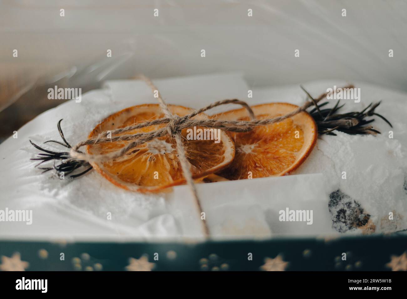Stollen de Noël décoré avec des fruits orange secs et branche d'épicéa. Cuisson des fêtes du nouvel an. Doux cadeau. Gâteau de Noël traditionnel enveloppé. Banque D'Images