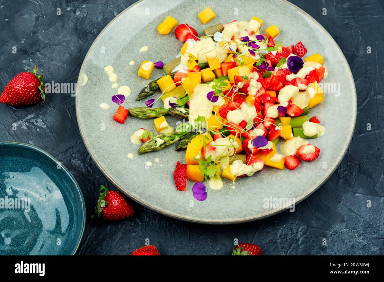 Salade légère de baies, asperges vertes, mangue, lilas et yaourt. Banque D'Images