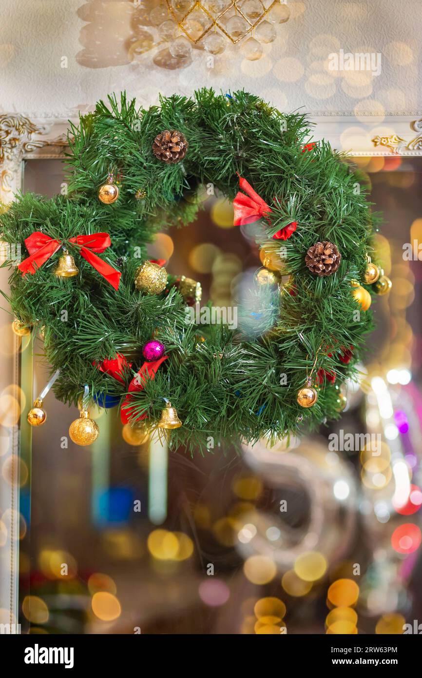 Une couronne de Noël avec des boules lumineuses. Décorer et décorer l'intérieur pour Noël et le nouvel an. Bokeh des lumières de la guirlande et le Banque D'Images
