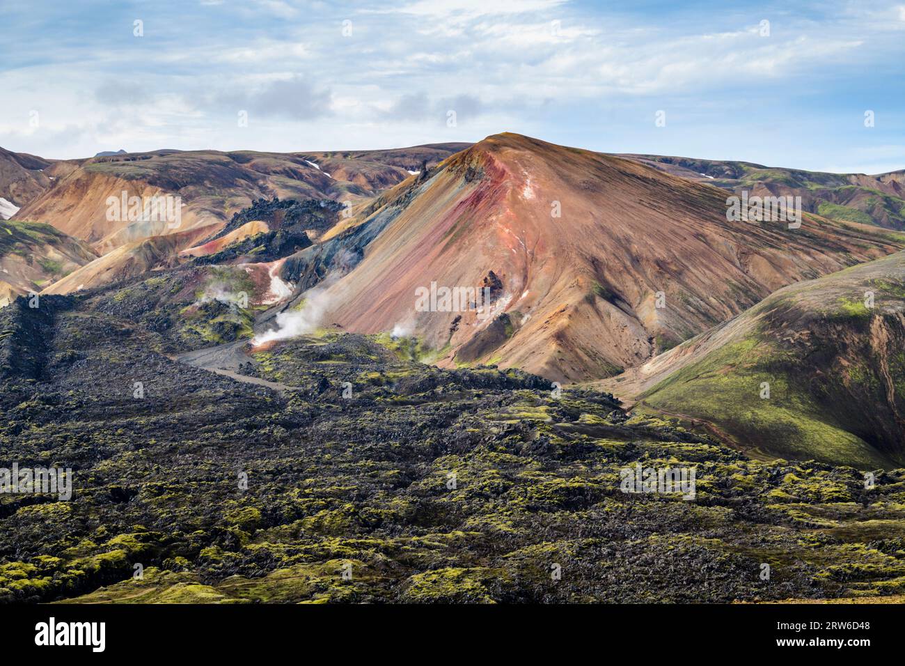 Red Brennisteinsalda Rhyolite Mountain entourée d'un champ de lave noir, Landmannalaugar, Islande Banque D'Images