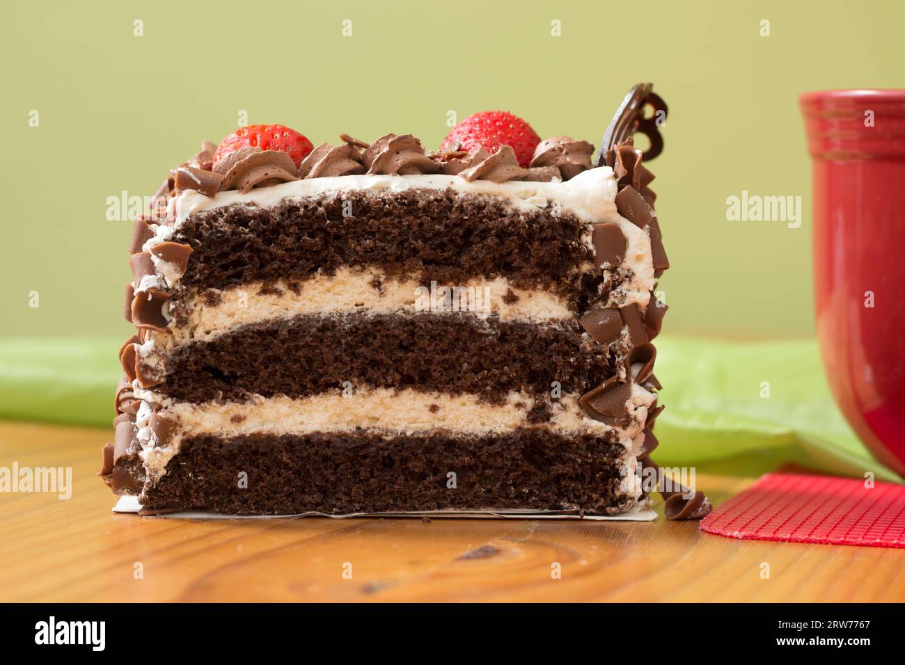 Une grande tranche de gâteau au chocolat et à la crème avec des fraises Banque D'Images