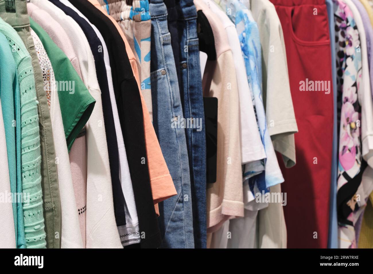 Vêtements de mode sur porte-vêtements Closeup de choix de couleur arc-en-ciel tenue féminine sur des cintres dans un placard de magasin de vêtements garde-robe d'été à la maison. Banque D'Images