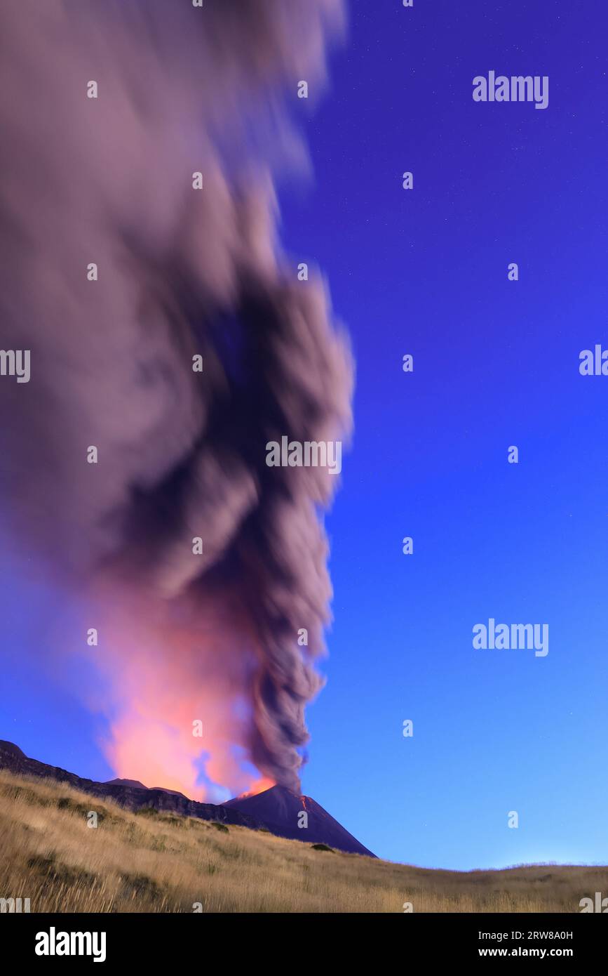 Éruption du volcan Etna vue à l’aube avec de grandes émissions de cendres du cratère avec ciel bleu en arrière-plan ; 13 août 2023 Banque D'Images