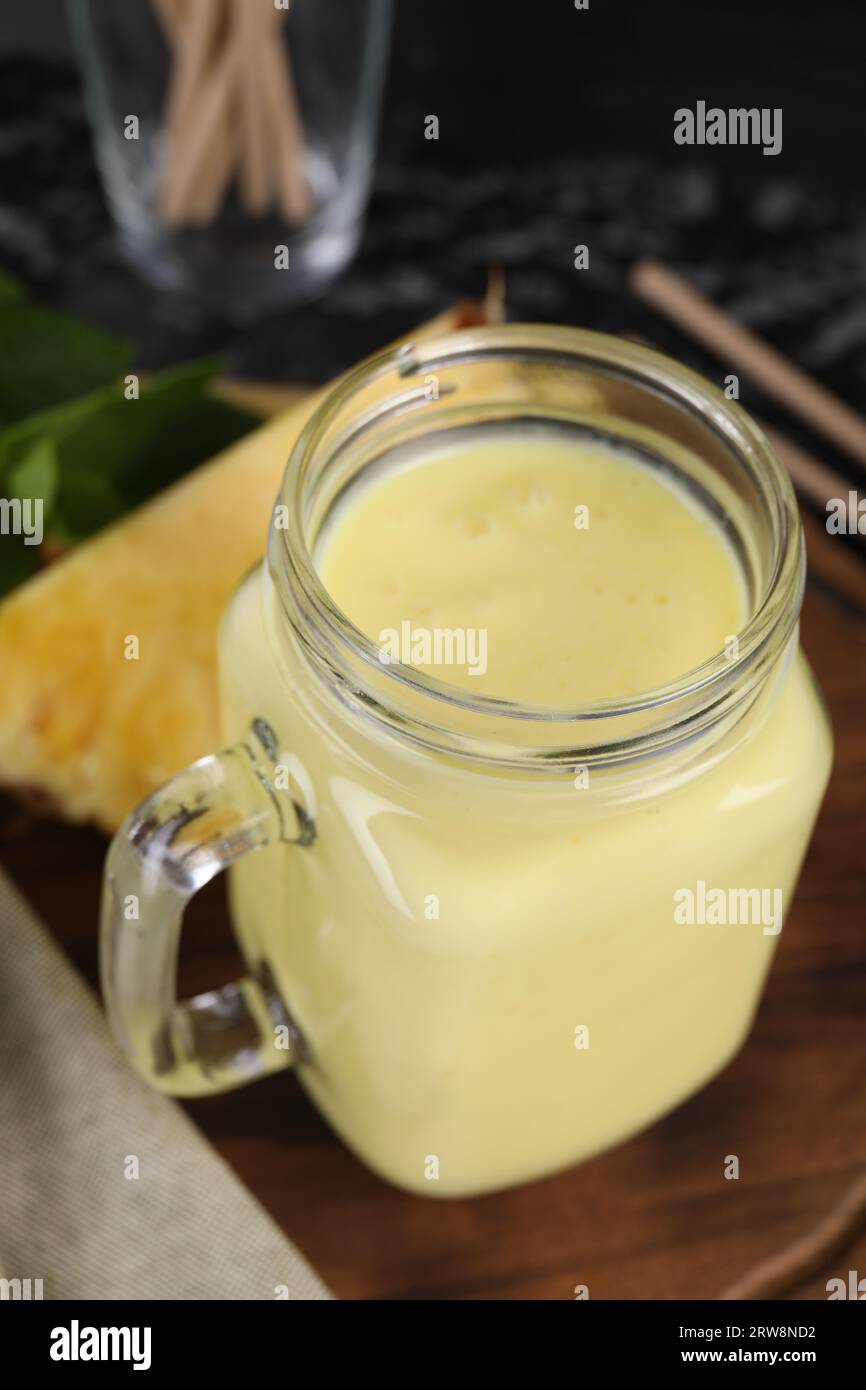 Savoureux smoothie à l'ananas dans un pot Mason sur la table, gros plan Banque D'Images
