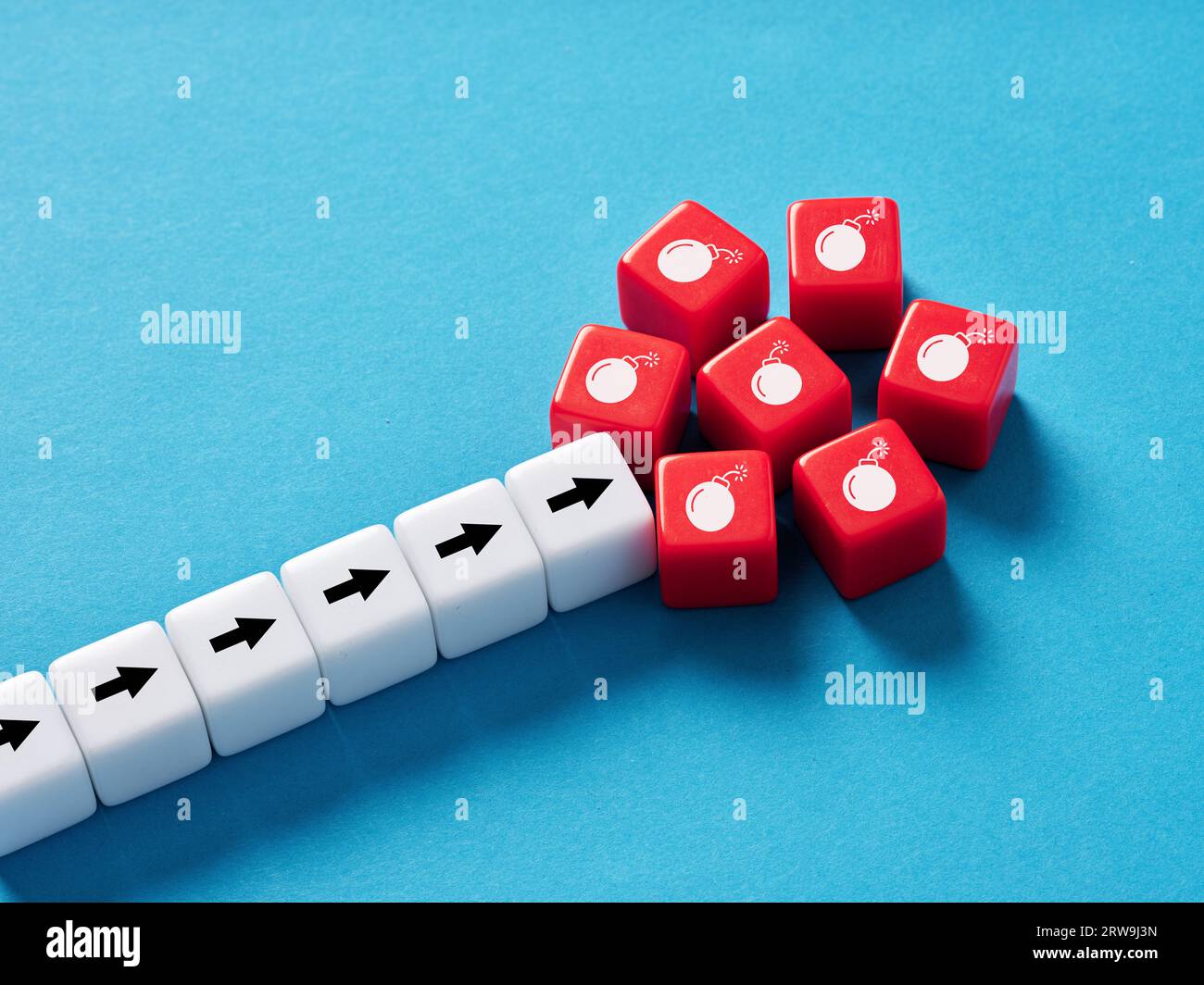 Faire face aux risques et aux menaces. Danger ou danger au bout de la route. Analyse des risques et échec. Symboles de bombe et de flèche sur les cubes. Banque D'Images