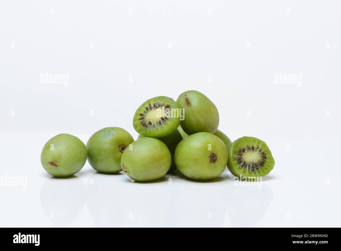 Mini kiwi, fruits entiers et coupés en deux (Actinidia arguta) Banque D'Images