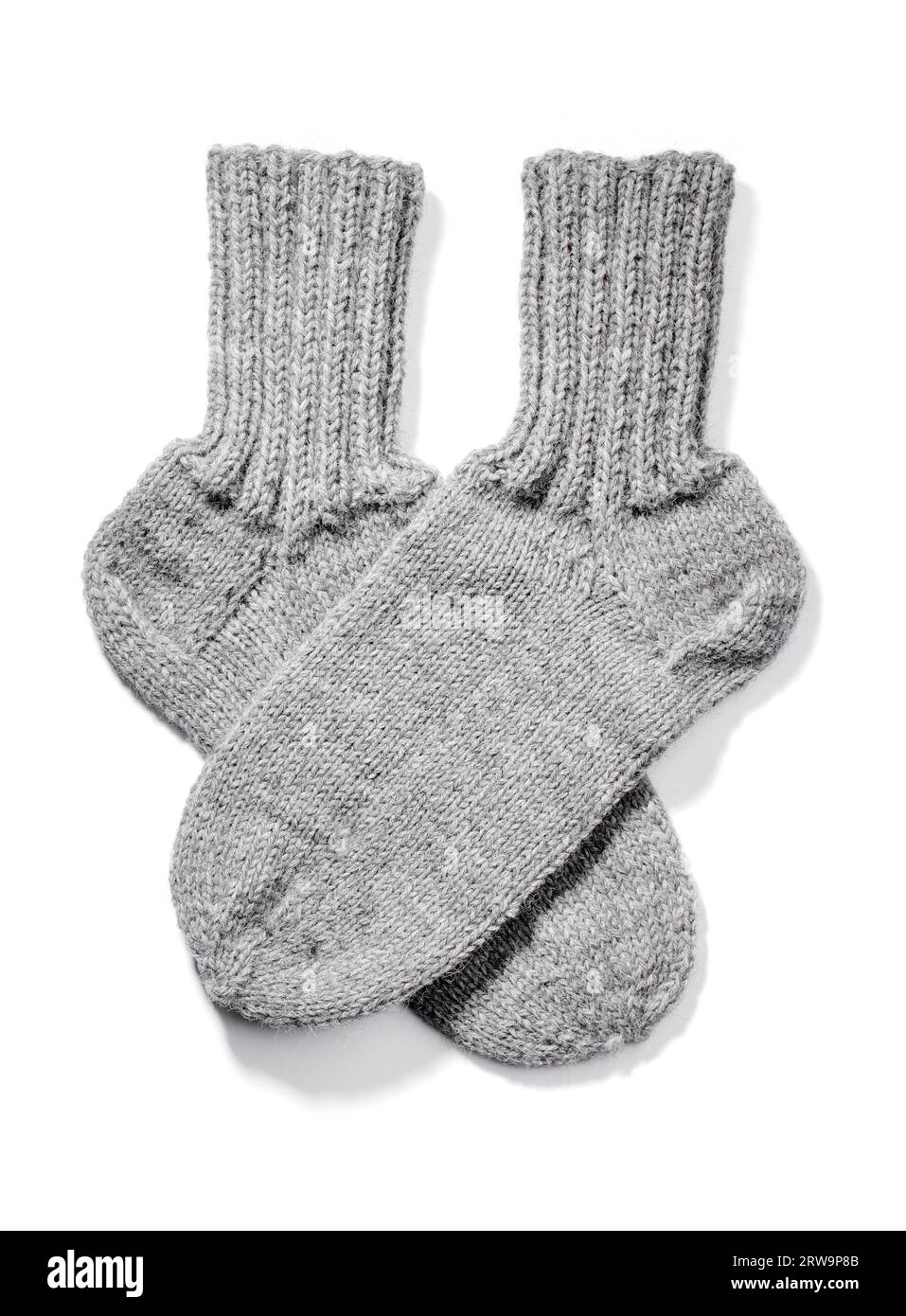 Chaussettes en laine chaude tricotées à la main isolées sur blanc avec des ombres naturelles Banque D'Images