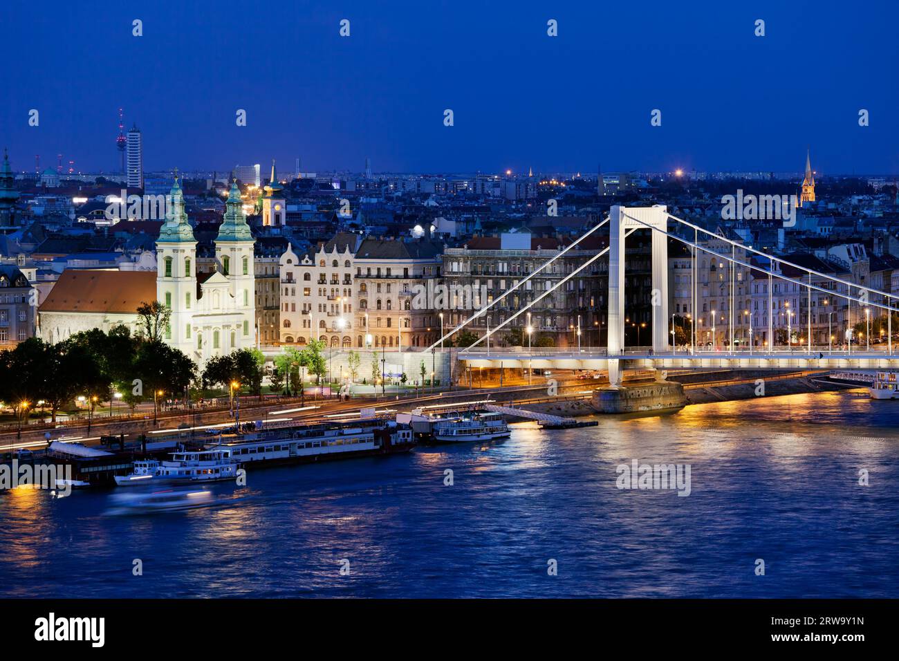 Paysage urbain de Budapest en Hongrie la nuit avec l'église paroissiale de la ville intérieure, les immeubles d'appartements et le pont Elizabeth au bord du Danube Banque D'Images