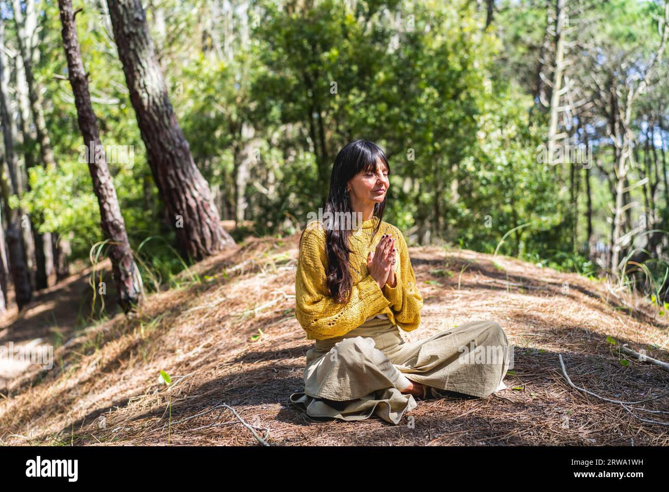 Femme aux mains serrées méditant sur les bois Banque D'Images