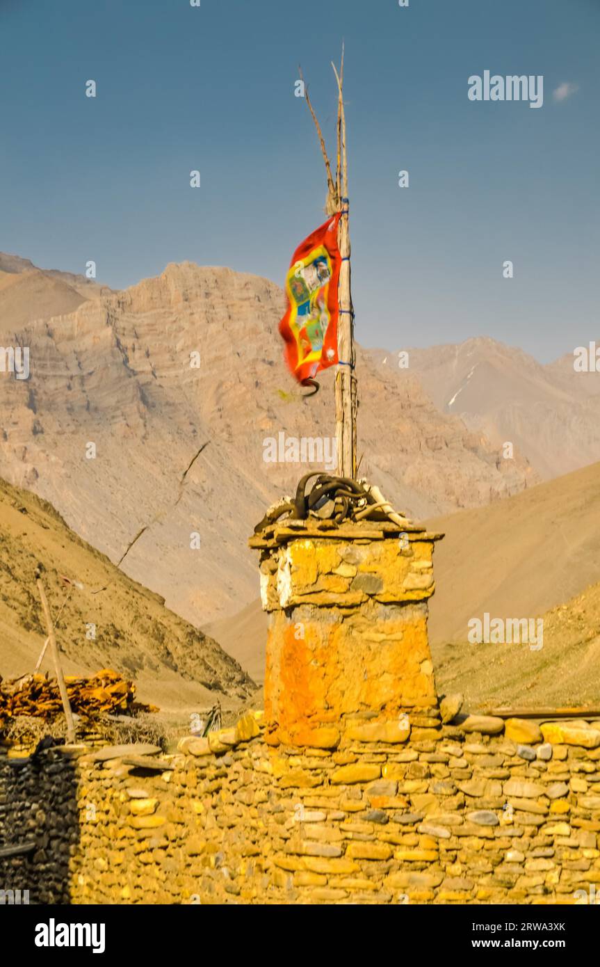 Photo de base en pierre avec bâton en bois et drapeau coloré dans la région montagneuse à Dolpo, Népal Banque D'Images