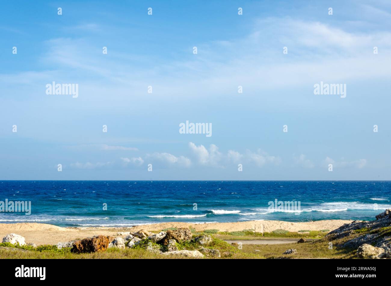 Sec et aride désert paysage avec vue sur la mer en arrière-plan dans les Caraïbes à l'île d'Aruba Banque D'Images