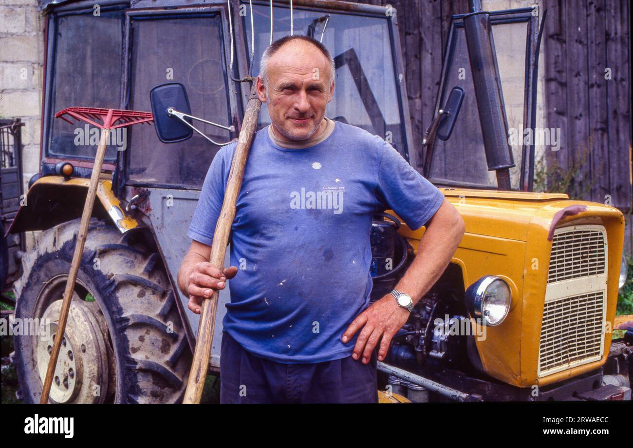 Pologne, Secemin, agriculteur devant son tracteur. Banque D'Images