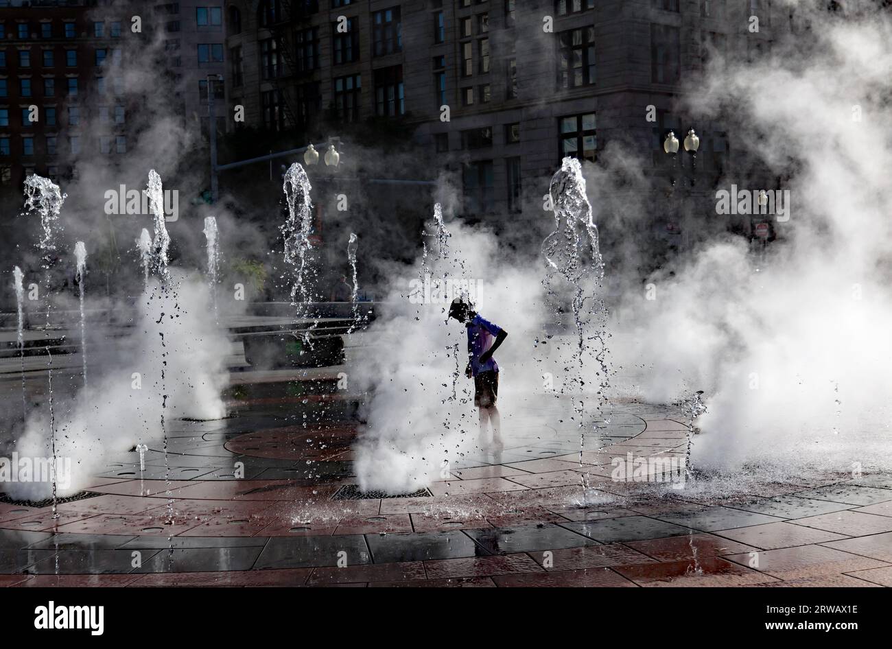 Vue atmosphérique d'un jeune garçon, appréciant Rings Fountain, au Greenway à Boston, USA Banque D'Images