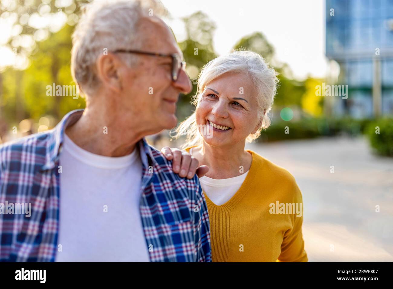 Portrait de couple senior heureux debout dans la rue de la ville par une journée ensoleillée Banque D'Images