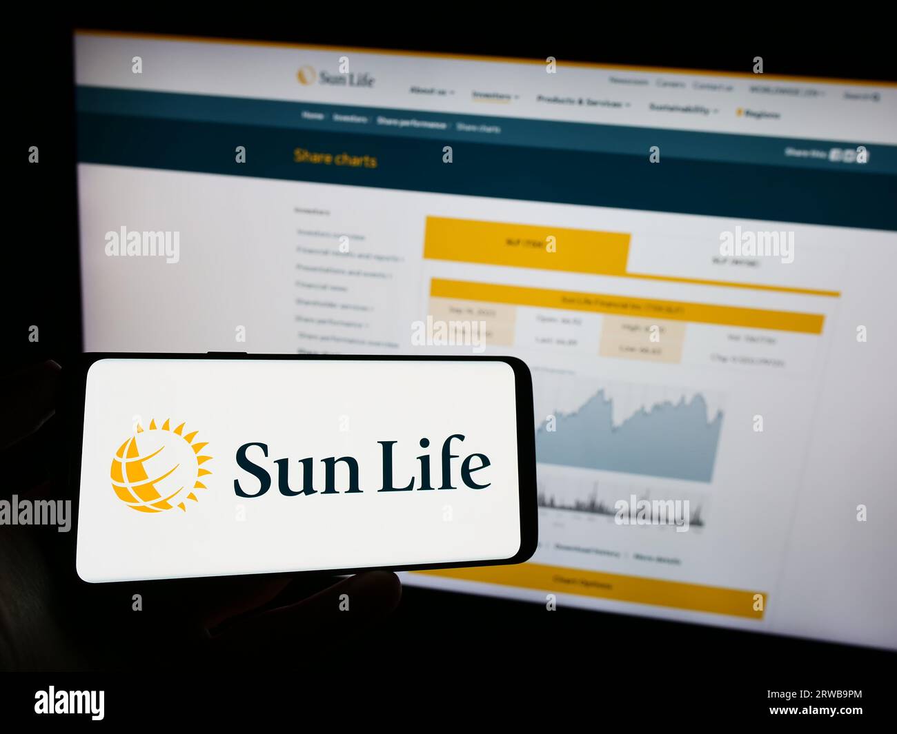 Personne détenant un téléphone mobile avec le logo de la société canadienne financière Sun Life Inc. À l'écran devant la page Web de l'entreprise. Concentrez-vous sur l'affichage du téléphone. Banque D'Images