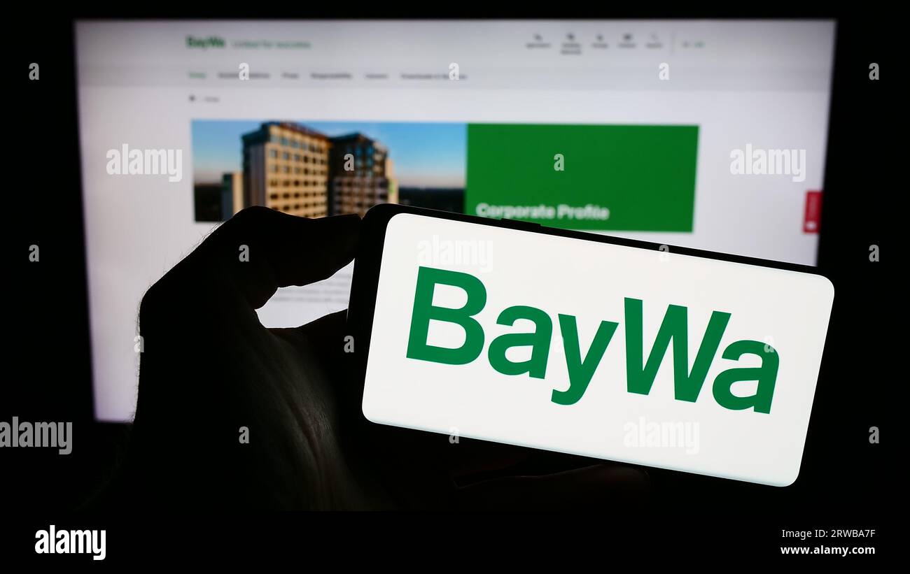 Personne tenant le smartphone avec le logo de la société agroalimentaire allemande BayWa AG sur l'écran en face du site Web. Concentrez-vous sur l'affichage du téléphone. Banque D'Images