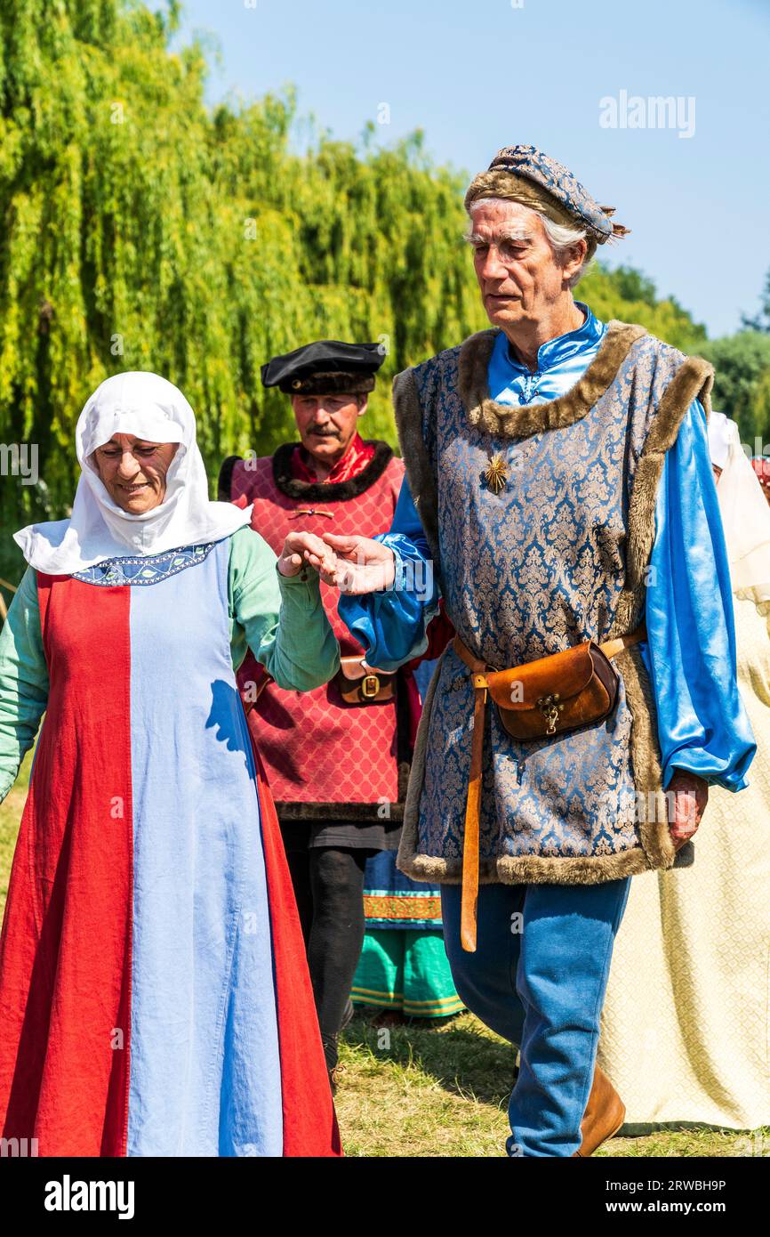 Bande médiévale de ménestrels, Rough Musicke, en costume d'époque dansant sur le green lors d'une reconstitution estivale à Sandwich Town dans le Kent. Banque D'Images