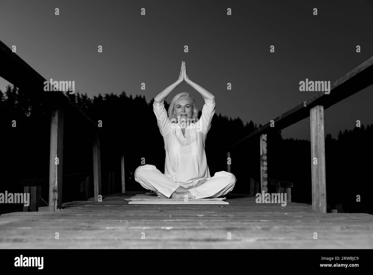femme d'âge moyen faisant du yoga à l'extérieur dans la forêt Banque D'Images