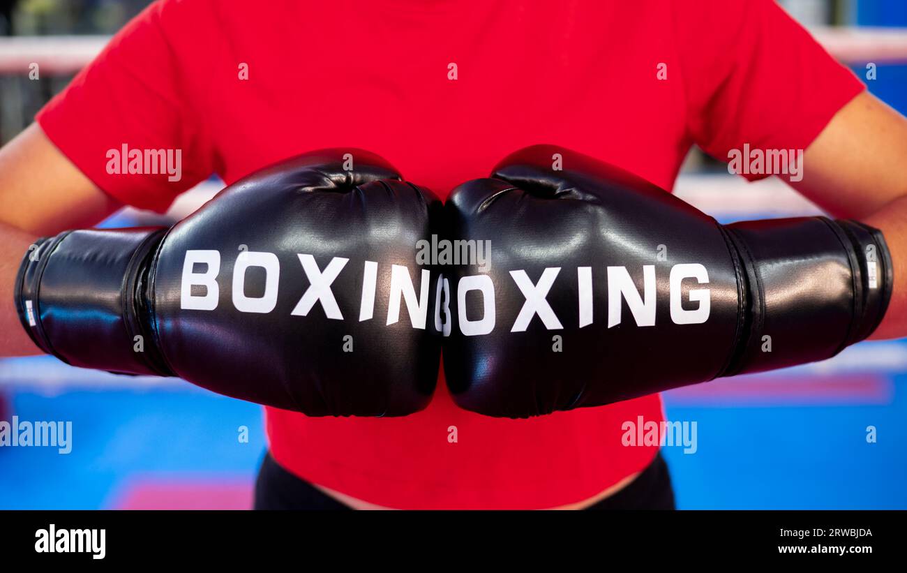 Paire de deux gants de poing de boxe rouge poinçonnant. Femme cognant. Compétition sportive de kickboxing. Banque D'Images
