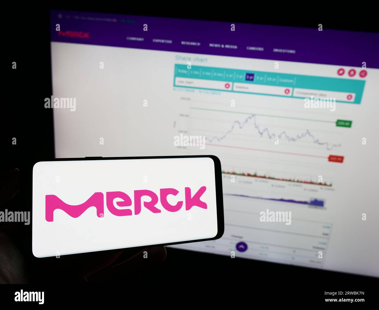 Personne tenant un téléphone portable avec le logo de la société pharmaceutique allemande Merck KGaA sur l'écran devant la page Web de l'entreprise. Concentrez-vous sur l'affichage du téléphone. Banque D'Images