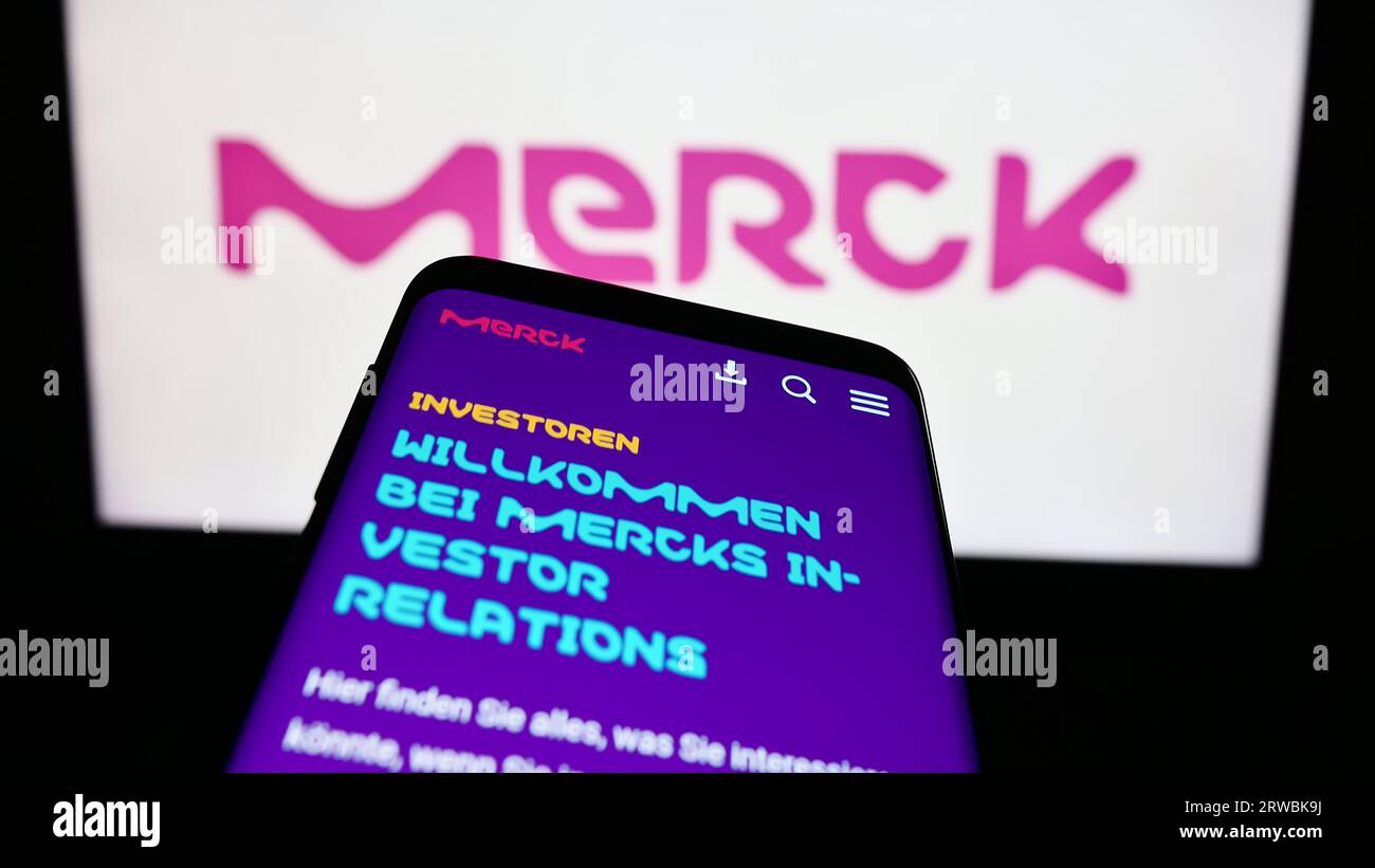 Téléphone portable avec le site Web de la société pharmaceutique allemande Merck KGaA sur l'écran devant le logo de l'entreprise. Effectuez le focus sur le coin supérieur gauche de l'écran du téléphone. Banque D'Images