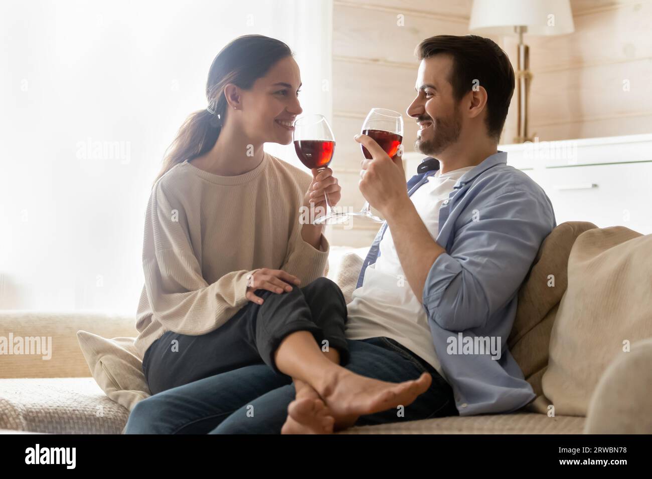 Homme heureux et femme buvant du vin rouge, appréciant la date romantique Banque D'Images